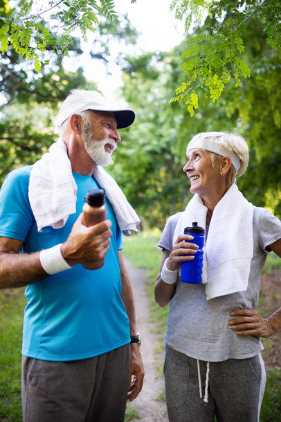 Beautiful sporty senior couple staying fit with running and jogging - Foto, Imagen