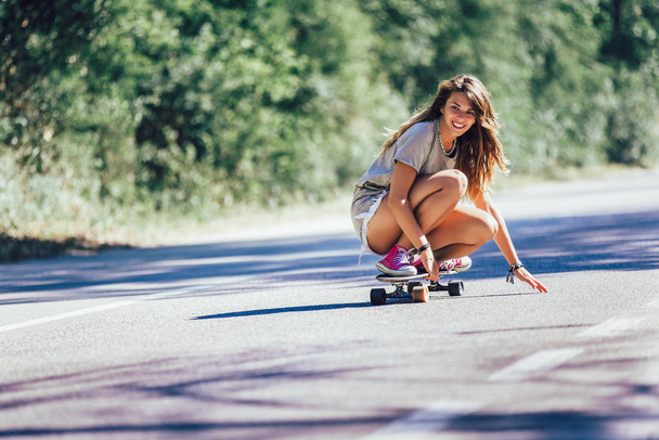 Mladá sportovní žena na skateboardu na silnici. - Fotografie, Obrázek