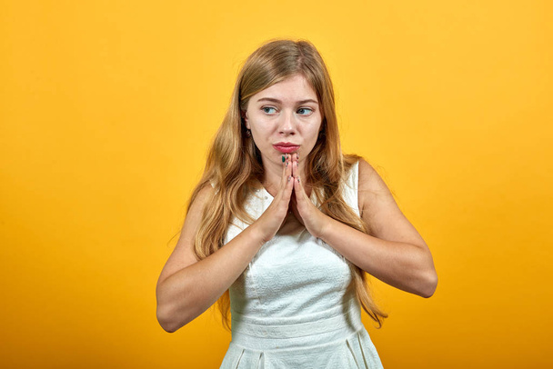 Φοβισμένη ελκυστική νεαρή γυναίκα κρατώντας τα χέρια μαζί, προσεύχεται, αναζητούν σύγχυση - Φωτογραφία, εικόνα