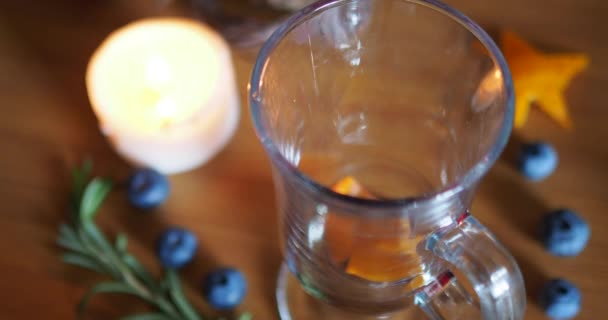Ζεστό ζεστό κρασί χύνεται σε ένα ιρλανδικό ποτήρι καφέ σε φόντο ξύλου. - Πλάνα, βίντεο