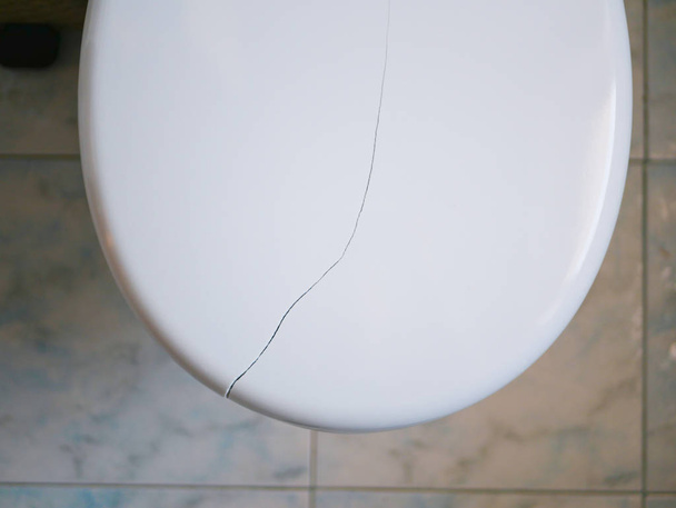 Coperchio per wc rotto. Crack sul coperchio della toilette. Primo piano - Foto, immagini