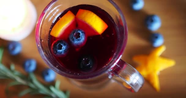 Blueberry τρέχει σε ένα ιρλανδικό ποτήρι καφέ με ζεστό κρασί σε φόντο ξύλου - Πλάνα, βίντεο