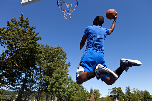 Uomo Dunking un pallacanestro
 - Foto, immagini
