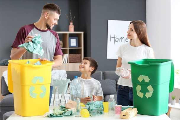Familie sorteren van vuilnis thuis. Concept van recycling - Foto, afbeelding