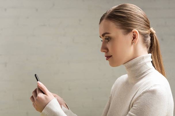 Side view of attractive woman using smartphone - Fotoğraf, Görsel