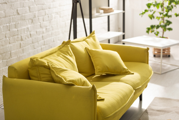 Comfortable yellow sofa with sunlight in living room - Fotó, kép