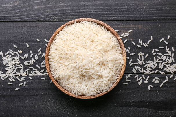 Plate with raw rice on wooden table - Zdjęcie, obraz