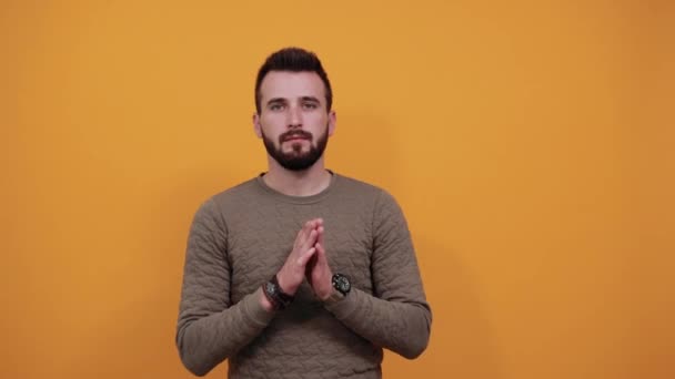 friedlicher kaukasischer Mann hält die Hände zusammen, betet, schaut in die Kamera - Filmmaterial, Video