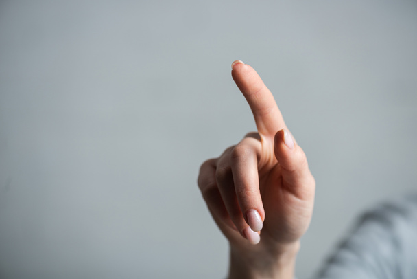 Cropped view of woman pointing with finger isolated on grey  - Foto, immagini
