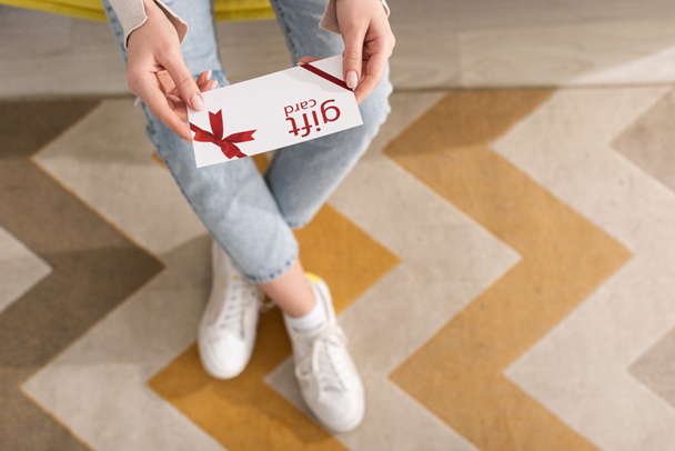 Cropped view of woman holding gift card at home - Photo, Image