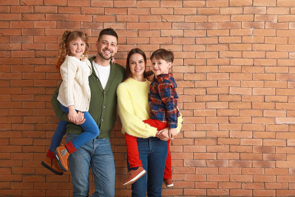 Happy family in winter clothes near brick wall - Photo, Image