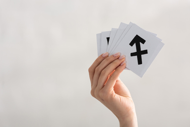 Cropped view of woman holding cards with zodiac signs isolated on grey - Photo, Image