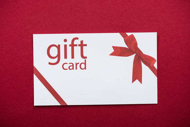Top view of gift card on red background - Foto, Imagen
