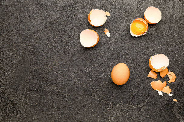 Broken fresh eggs on dark background - Foto, Bild