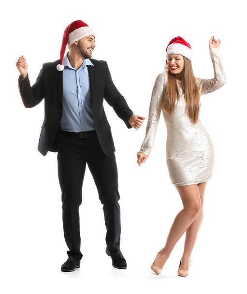 Счастливая пара в шляпах Санта-Клауса на белом фоне
 - Фото, изображение