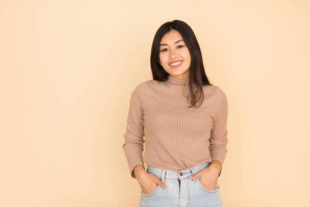 portret van aziatisch meisje op perzik achtergrond, glimlachen naar camera - Foto, afbeelding