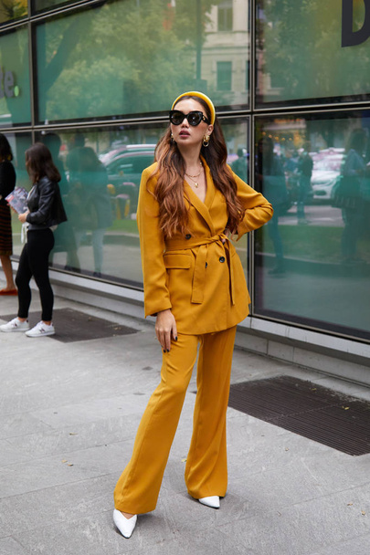 Woman with yellow jacket and trousers before Emporio Armani fashion show, Milan Fashion Week street style  - Foto, Imagem