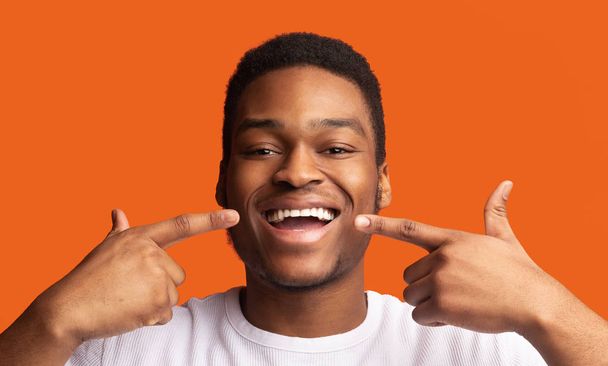 Zwarte man glimlachen en tonen perfecte gezonde tanden - Foto, afbeelding