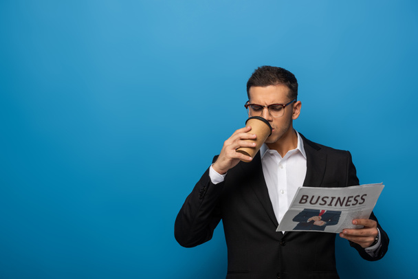 Komea liikemies kahvia mennä lukemaan sanomalehteä sinisellä pohjalla
 - Valokuva, kuva