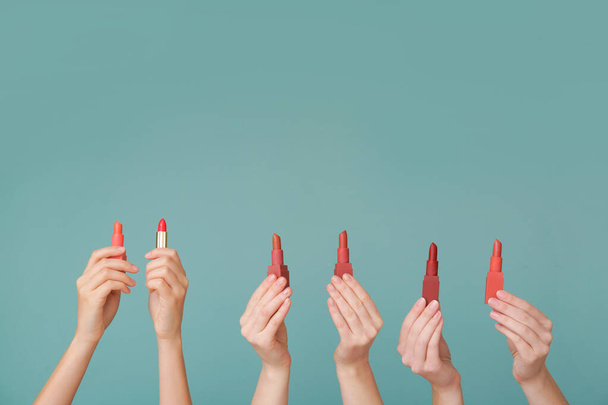 Жіночі руки з помадами на кольоровому фоні
 - Фото, зображення