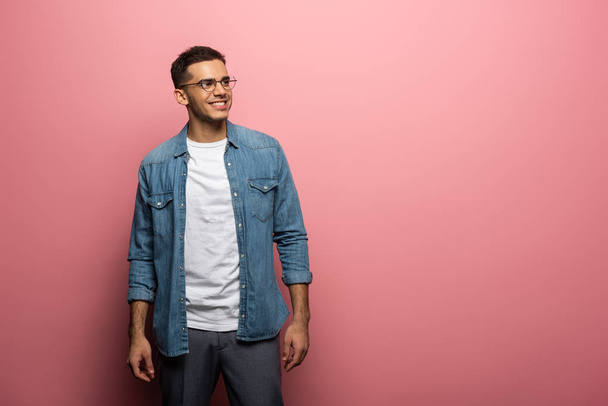 Handsome man smiling away on pink background with copy space - Photo, Image