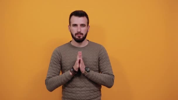 Békés jóképű kaukázusi férfi tartja egymás kezét, imádkozik, kamerába néz - Felvétel, videó