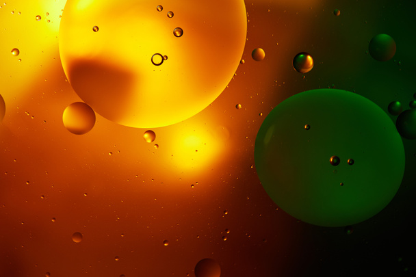 abstrakter Hintergrund aus Mischwasser und Öl in orange und grün - Foto, Bild
