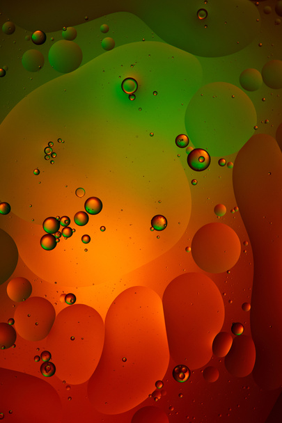 混合水と油泡からの緑と赤の抽象的な背景  - 写真・画像
