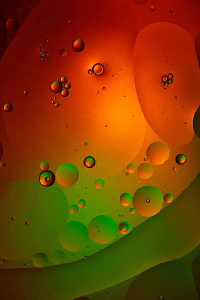 abstract background from mixed water and oil bubbles in green and red color - Photo, Image