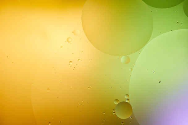 Όμορφο αφηρημένο φόντο από μικτό νερό και λάδι σε μωβ, πορτοκαλί και πράσινο χρώμα - Φωτογραφία, εικόνα
