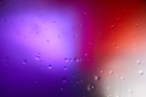 elvont lila és piros színű háttér vegyes víz és olaj buborékok - Fotó, kép
