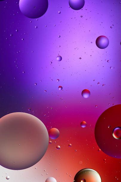 kreative abstrakte lila und rote Farbtextur aus gemischten Wasser- und Ölblasen - Foto, Bild