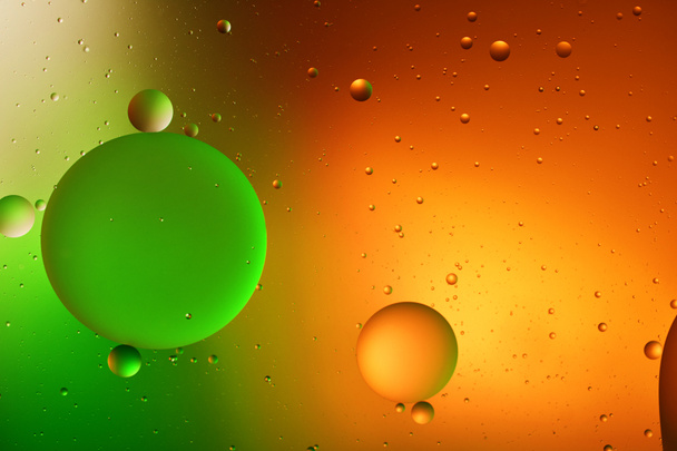 Mooie abstracte achtergrond van gemengd water en olie in oranje, rode en groene kleur - Foto, afbeelding