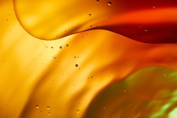 Beautiful abstract background from mixed water and oil in orange, red and green color - Foto, afbeelding