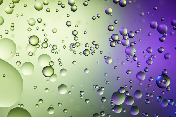 abstracte paarse en groene kleur achtergrond van gemengd water en olie bellen - Foto, afbeelding