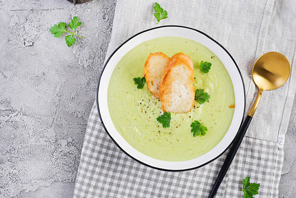 Soupe de crème de brocoli maison avec croûtons dans un bol blanc sur fond gris. Nourriture végétarienne saine. Menu végétalien. Vue du dessus, espace de copie
 - Photo, image