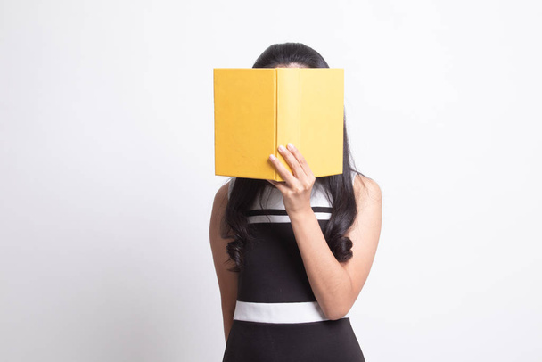 Young Asian woman with a book cover her face. - Zdjęcie, obraz