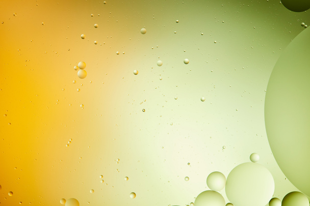 creative abstract background from mixed water and oil in green and orange color - Foto, afbeelding
