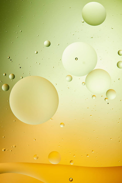 creative background from mixed water and oil in green and orange color - Foto, afbeelding
