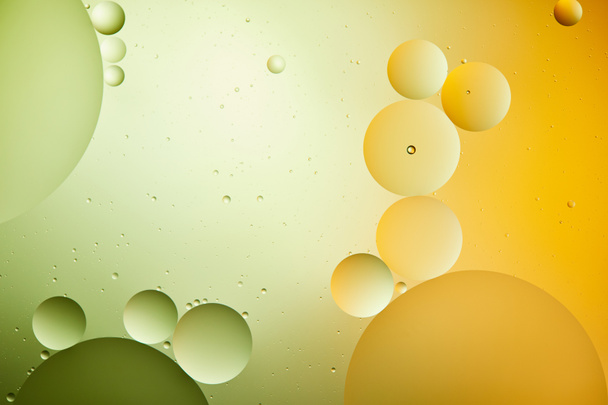 Karışık su ve yağın yeşil ve turuncu renklerdeki yaratıcı soyut arkaplanı - Fotoğraf, Görsel
