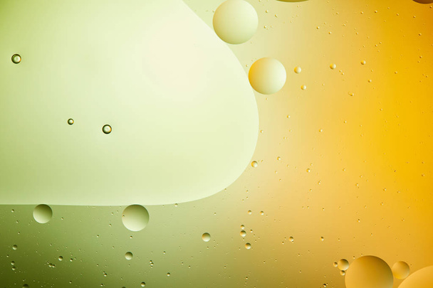 Beautiful abstract background from mixed water and oil in green and orange color - Foto, Imagen