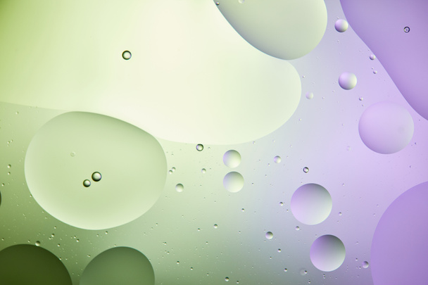 fondo abstracto de agua mezclada y aceite en color verde claro y púrpura
 - Foto, Imagen