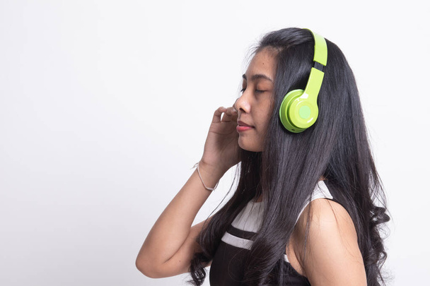 Pretty asian girl listening music with her headphones. - Фото, изображение