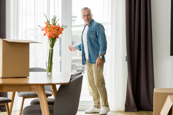 handsome mature man in shirt standing in new house  - Photo, image