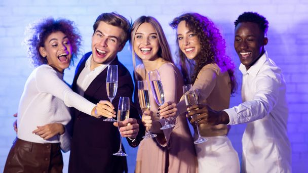 Amici gioiosi Clinking Champagne Flauti che celebrano il nuovo anno in piedi al coperto
 - Foto, immagini