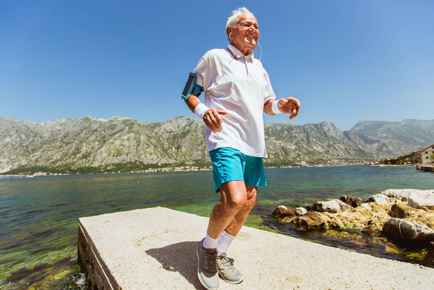 feliz hombre mayor haciendo ejercicio matutino en la playa
 - Foto, Imagen