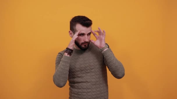 Handsome cheerful man keeping fingers on head, thinking about issue - Video
