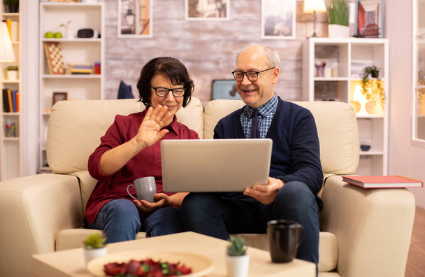 Anziani vecchia coppia utilizzando il computer portatile moderno per chattare con il nipote
 - Foto, immagini