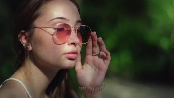 Outdoor portret van flirterige brunette in zonnebril - Video