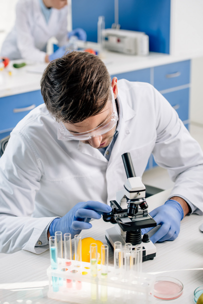 nutricionista molecular em casaco branco usando microscópio em laboratório
  - Foto, Imagem